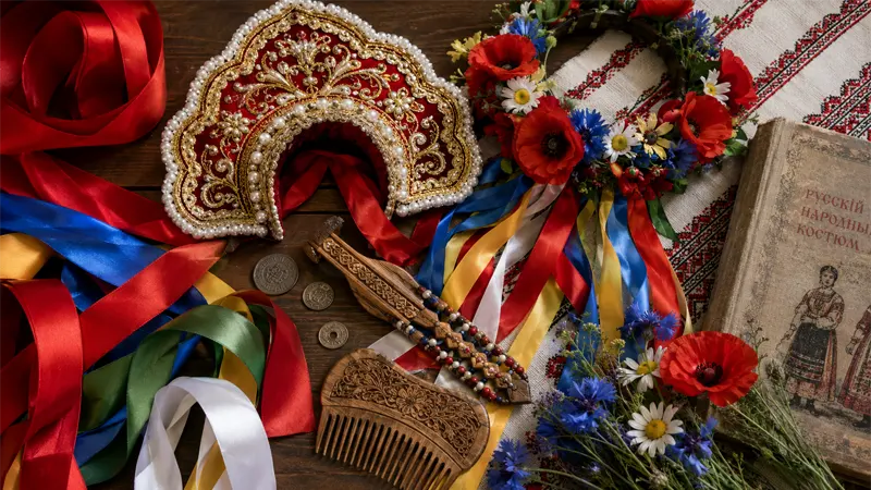 Slavic braid accessories flat lay including ribbons, kokoshnik, vinok flower crown, and nakosniki